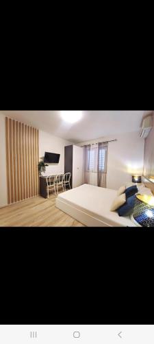 a bedroom with a large bed and a flat screen tv at Apartments Gavran 3 in Baška Voda