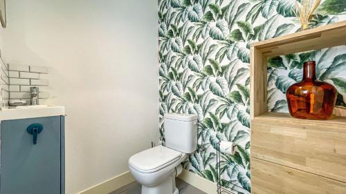 La salle de bains est pourvue de toilettes et de papier peint à fleurs. dans l'établissement HOMEY CHLOE - New - Parking gratuit - Balcon privé - Proche Genève, à Annemasse