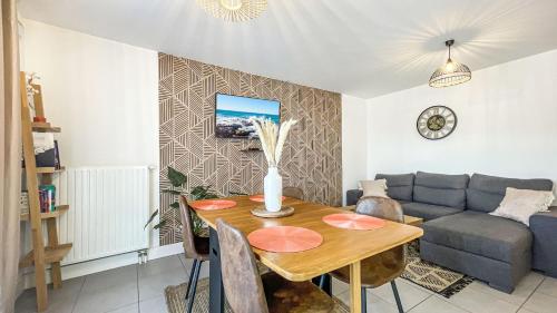 un salon avec une table et un canapé dans l'établissement HOMEY CHLOE - New - Parking gratuit - Balcon privé - Proche Genève, à Annemasse