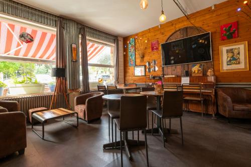 un ristorante con bar con tavoli e sedie di Hôtel Les Pins a Saint-Trojan-les-Bains