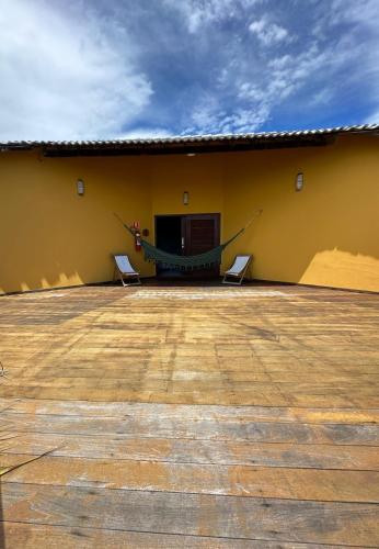 a patio with two chairs and a building at Pousada Vento do Kite in Barra Grande