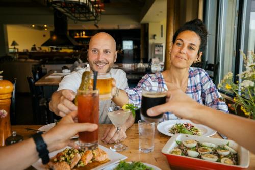 un gruppo di persone sedute a tavola che mangiano cibo di Auberge de Montagne des Chic-Chocs Mountain Lodge - Sepaq a Sainte-Anne-des-Monts