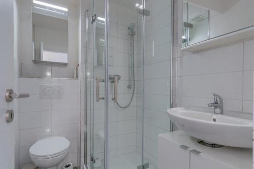 uma casa de banho com um WC, um lavatório e um chuveiro em Ferienpark-Sierksdorf-Haus-5-WE-595 em Sierksdorf