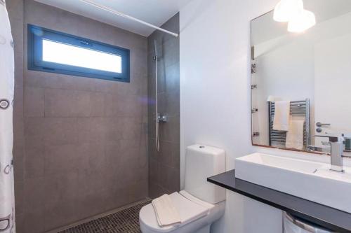 a bathroom with a toilet and a sink and a mirror at Casa Noa in Alcudia