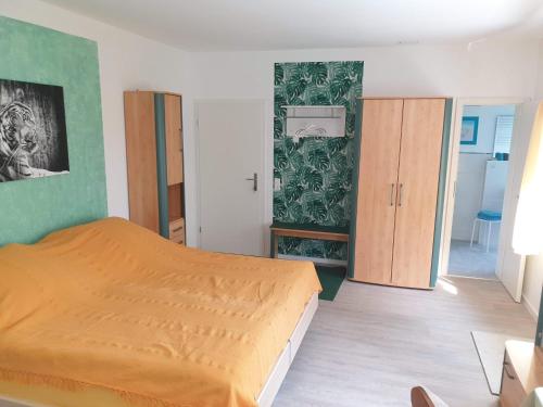 ein Schlafzimmer mit einem orangenen Bett und einer grünen Wand in der Unterkunft Pension Weitblick 