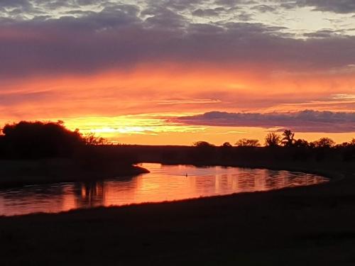 a sunset over a river with the sun setting at Pension Weitblick in Stehla