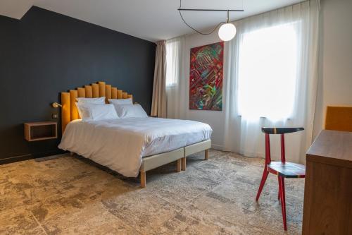 - une chambre avec un grand lit et une fenêtre dans l'établissement Hôtel Les Pins, à Saint-Trojan-les-Bains