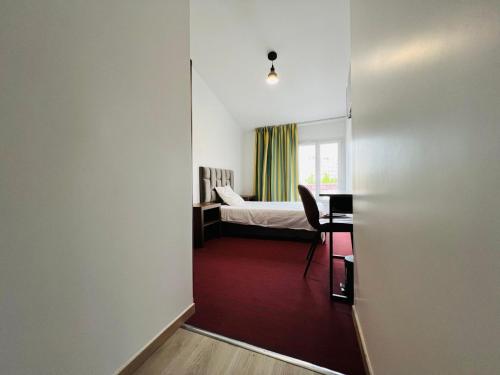 Zimmer mit einem Schlafzimmer mit einem Bett und einem Schreibtisch in der Unterkunft Auberge de Bagneux in Bagneux
