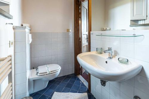 a white bathroom with a sink and a toilet at La Casettina del Forno in Santa Maria di Castellabate