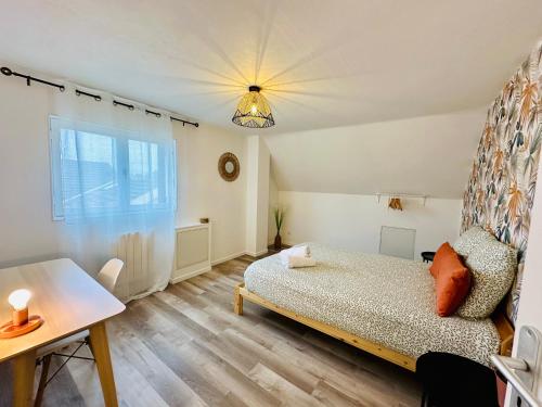 een slaapkamer met een bed, een tafel en een raam bij Maison Le M - Disneyland JO Paris 2024 Parking in Chessy