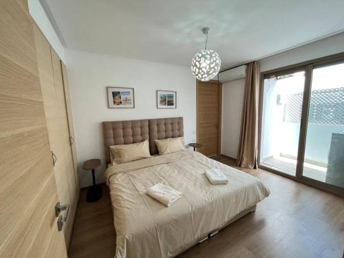 a bedroom with a large bed and a large window at Charme et Confort au Centre de Casablanca in Casablanca