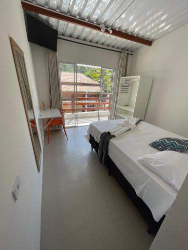 um quarto com uma cama e uma grande janela em Pousada Uchimura em Itapecerica da Serra