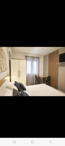 a hotel room with two beds and a table at Apartments Gavran 3 in Baška Voda