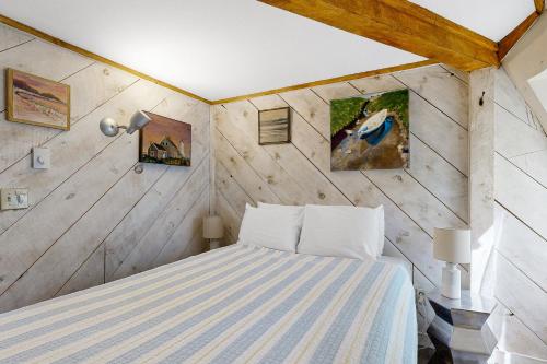 1 dormitorio con 1 cama en una habitación con paredes de madera en The Dome House, en Trevett