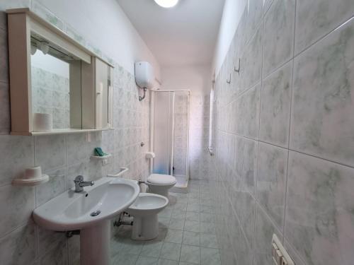 ein weißes Bad mit einem Waschbecken und einem WC in der Unterkunft Villaggio Camping Lungomare in Cropani