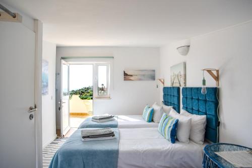 Schlafzimmer mit einem großen Bett mit blauem Kopfteil in der Unterkunft Mirabilia Luz - Altavista in Luz