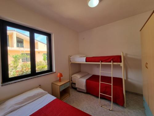 a bedroom with two bunk beds and a window at Villaggio Camping Lungomare in Cropani