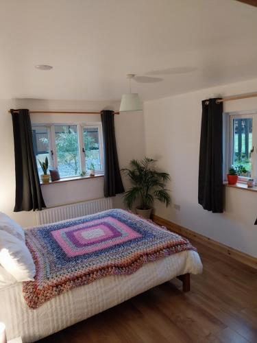 a bedroom with a bed with a rug on it at Felicity Cottage in Kiltegan