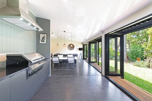 an open kitchen and dining room with sliding glass doors at Home among the Gum Trees - free wine in Modbury