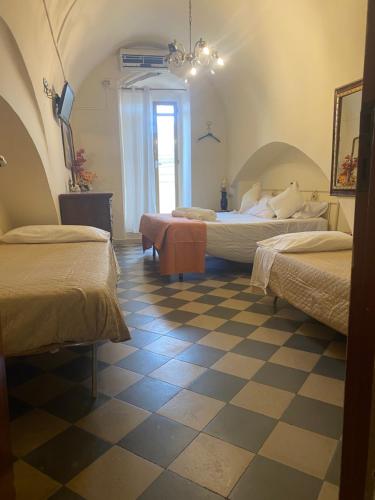um quarto com 2 camas e um piso em xadrez em Centralissimo 50mt em Matera