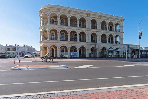 a person riding a bike in front of a building at Serenity by the Sea - 4BR Home with beach views in Largs