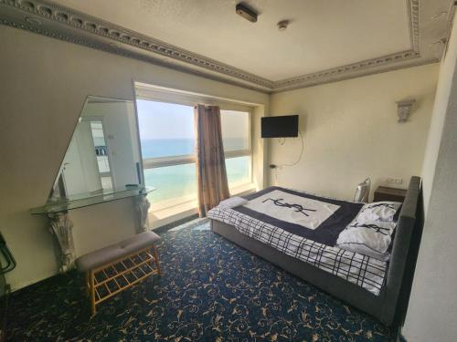 a bedroom with a bed and a large window at Leonardo hotel , Very luxury suite, high floor, in fron of See in Bat Yam