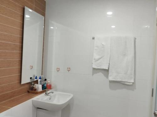 a white bathroom with a sink and a mirror at AMI POLARIS 23 Apartment-Residence in Phnom Penh
