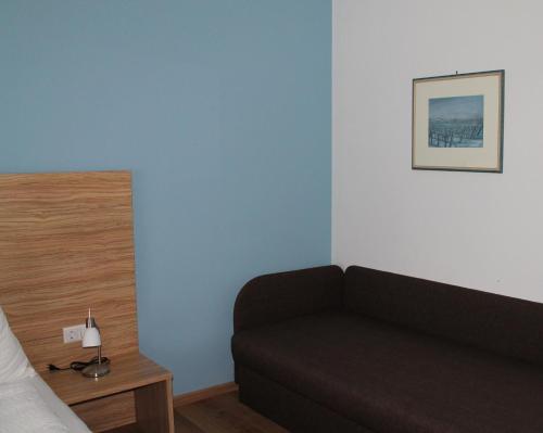 a bedroom with a couch and a picture on the wall at Ferienhof Weingut Lunzer in Gols
