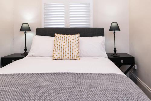a bedroom with a white bed with two lamps at Lovely and Spacious 2-bedroom home in Norwood in Adelaide