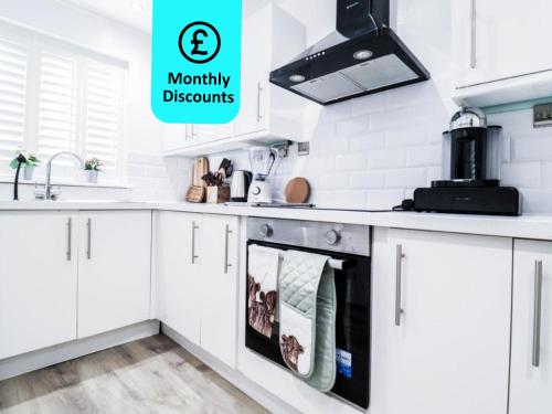 a kitchen with white cabinets with the words mummy discounts at Tranquil 3BR Retreat for Families in Bexleyheath in Bexleyheath
