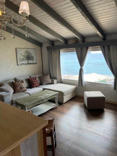 a living room with a couch and a large window at Hamre Apartments (Nicholas) in Agios Georgios Pagon