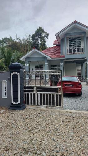 ein rotes Auto, das vor einem Haus parkt in der Unterkunft IIY Homestay in Pasir Mas