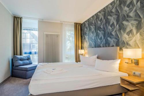 um quarto com uma grande cama branca e uma cadeira azul em Hotel Alter Markt em Berlim