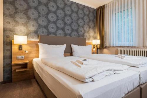 duas camas num quarto de hotel com lençóis brancos em Hotel Alter Markt em Berlim