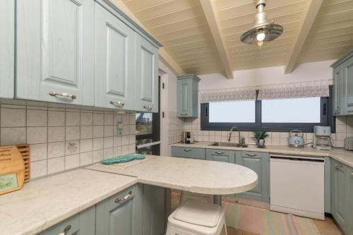 a kitchen with blue cabinets and a marble counter top at Le Mar Villa in Vasilikos