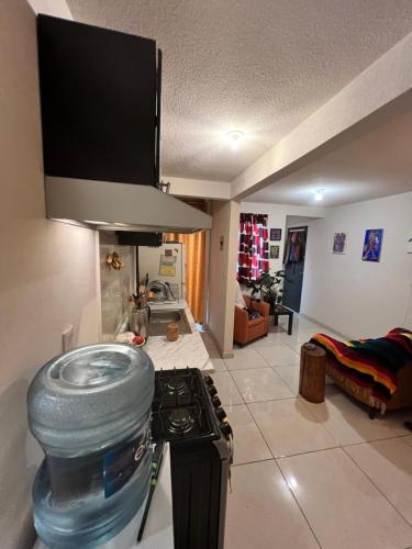 a kitchen with a stove and a living room at Rooftop Paradise Central Location, Scenic Views in Mexico City