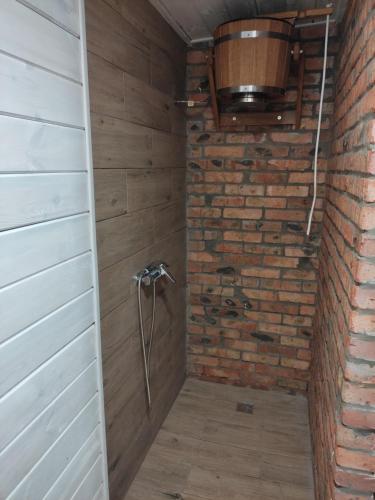 a shower in a room with a brick wall at Сімейний куточок in Svityazʼ