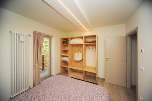 1 dormitorio con 1 cama y 1 habitación con ventana en Appartamento Cembro, en Ossana