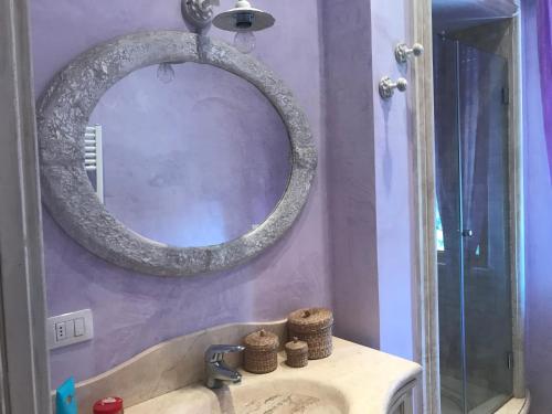 baño con lavabo y espejo en la pared en Appartamento sul mare la Conchiglia, en San Vincenzo