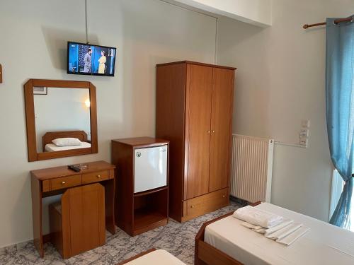 a bedroom with a bed and a mirror and a dresser at Indigo sea view rooms in Olympiaki Akti