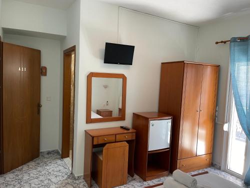 a room with a mirror and a dresser and a television at Indigo sea view rooms in Olympiaki Akti