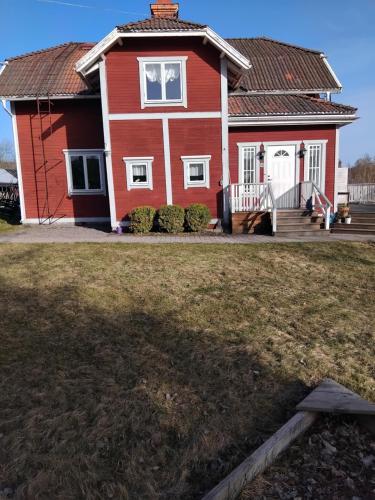 a red house with a large yard in front of it at Röda villan in Grycksbo