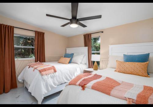 um quarto com 2 camas e uma ventoinha de tecto em Chic Naples cottage 7 min from the beach em Naples