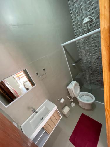 a bathroom with a sink and a toilet and a shower at Pousada Uchimura in Itapecerica da Serra