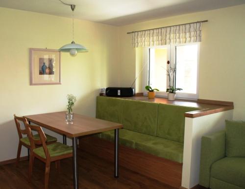 a living room with a table and a green couch at Ferienhof Weingut Lunzer in Gols