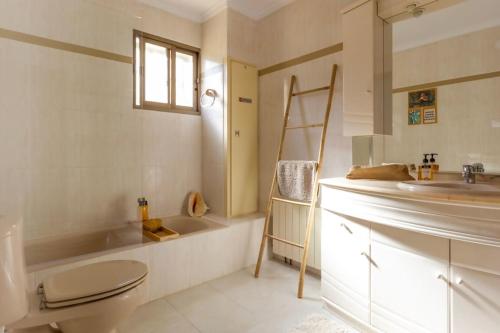 een badkamer met een wastafel, een toilet en een bad bij La Villa del Sol in Oliva