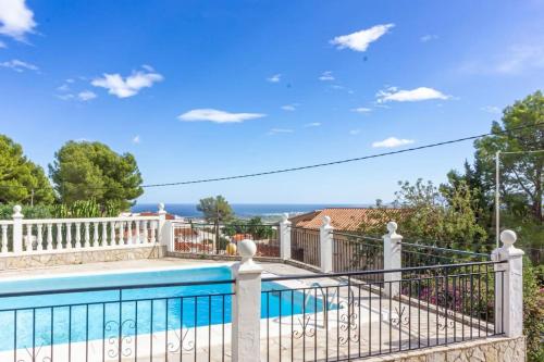 een huis met een zwembad en een hek bij La Villa del Sol in Oliva