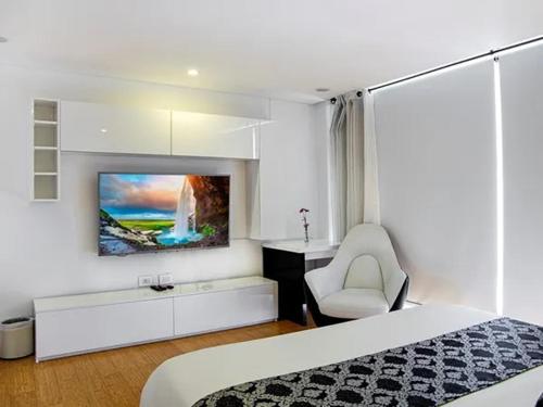 um quarto com uma cama e uma televisão na parede em Edificio Monir em Bogotá