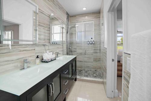 La salle de bains est pourvue d'un lavabo et d'une douche. dans l'établissement Ohana House Jacuzzi Pool and Ping Pon Terrace, à Homestead