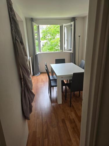 ein Esszimmer mit einem Tisch, Stühlen und einem Fenster in der Unterkunft 10min from Paris 3 bedrooms parking in Asnières-sur-Seine